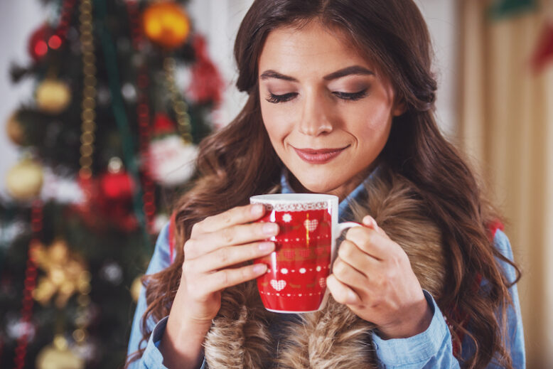 A young woman is happy while celebrating Christmas at home