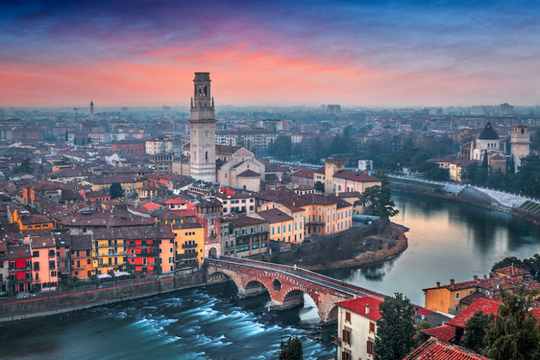 Verona, Italy town skyline on the Adige River at dusk.