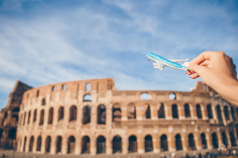 Closeup toy airplane on Colosseum background. Italian european vacation in Rome. Concept of imagination.