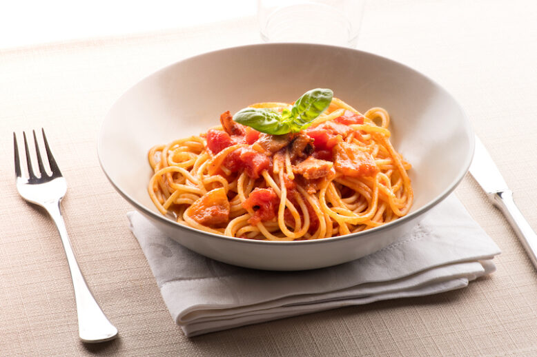 Spaghetti all' amatriciana from the Lazio region of Italy with pecorino cheese, pepper, tomato, cured pork jowl or guanciale served in a bowl as a first course to Italian cuisine