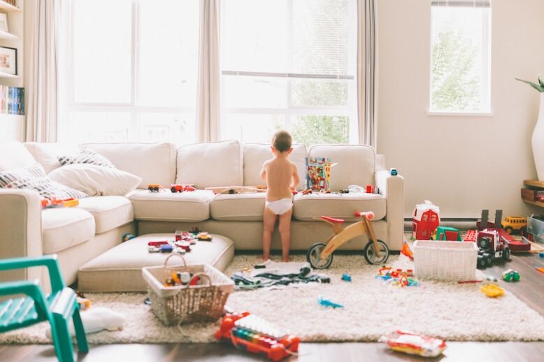Messy living room with toddler playing