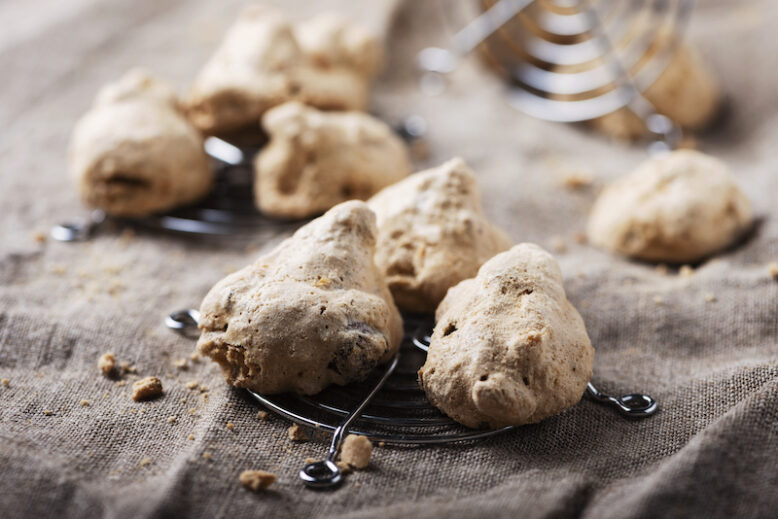 Traditional Piedmont cookies «Buoni ma brutti» with nuts, selective focus