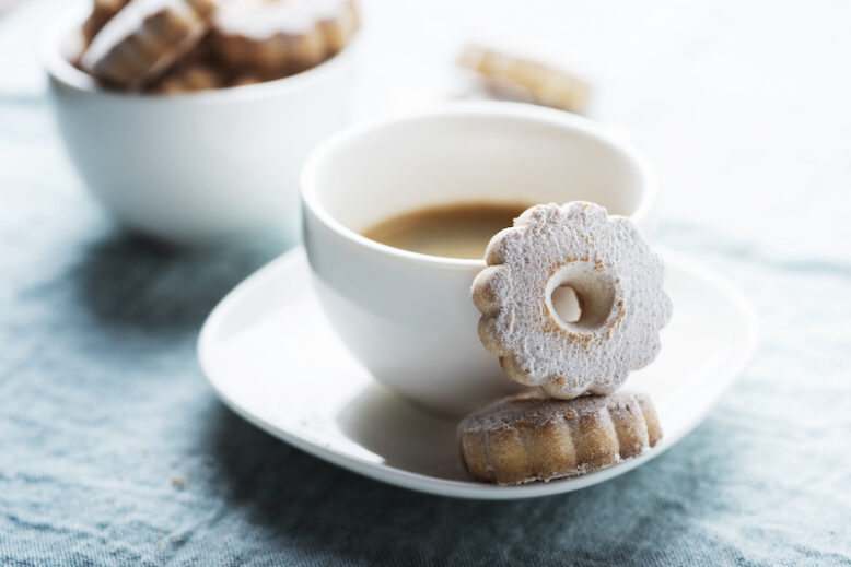 Italian traditional cookies canestrelli with a cup of coffee, selective focus