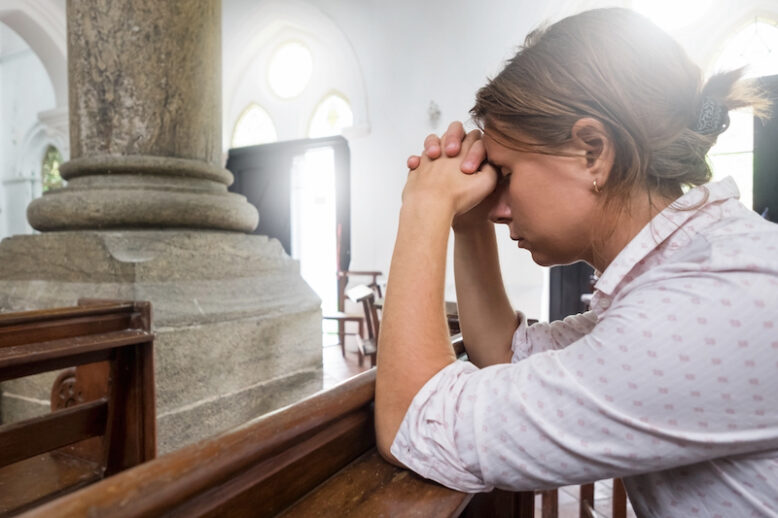 Praying woman in christian church.