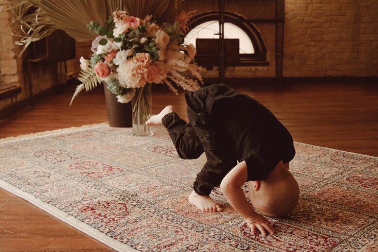 Little boy tumbling on the floor on the carpet