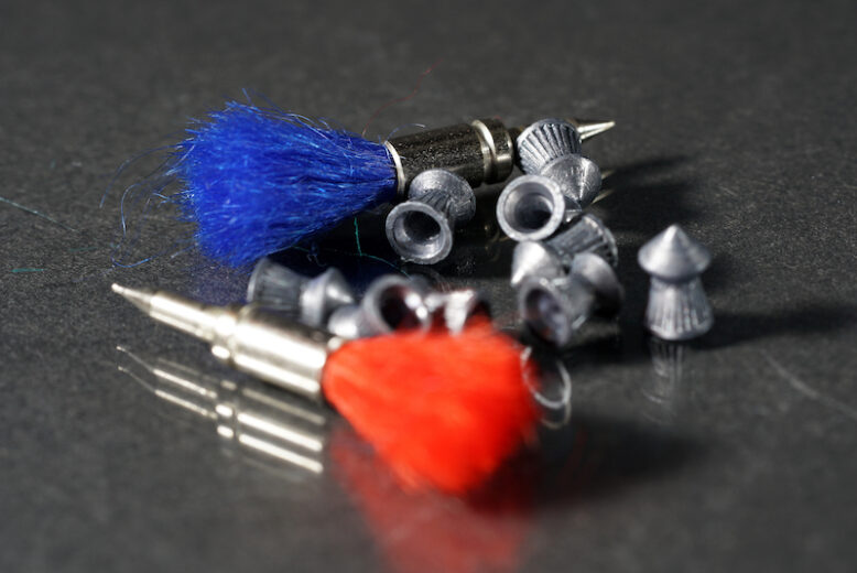 A selective focus closeup shot of tranquilizer darts with other small tools around