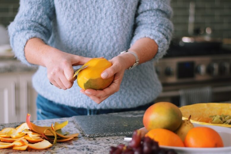 Woman peeling mango