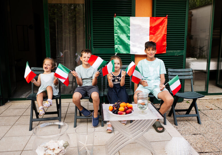 Happy four kids with italian flags celebrating Republic Day of Italy.