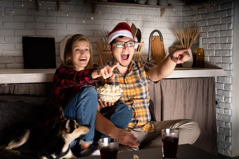 young couple watching a chirstmas movie at home