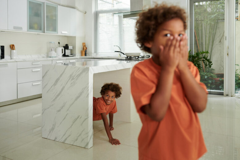 Cheerful brothers playing hide and seek at home