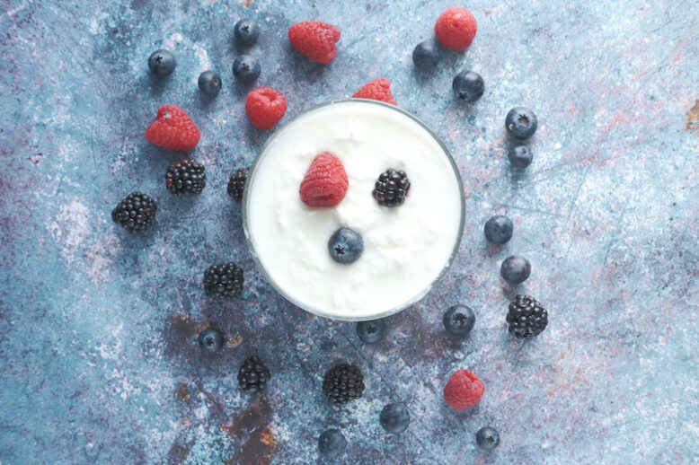 close up of fresh yogurt with blue berry in a bowl .