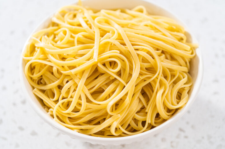 Large bowl with linguine pasta on a kitchen counter.