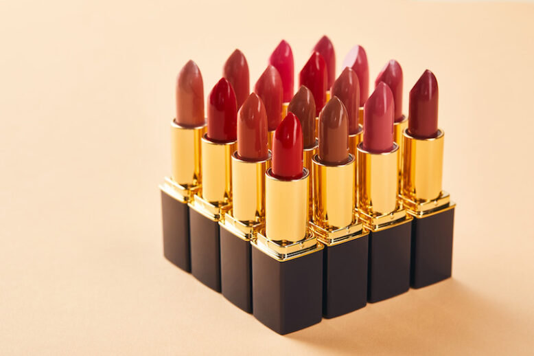 various red lipstick in tubes on beige