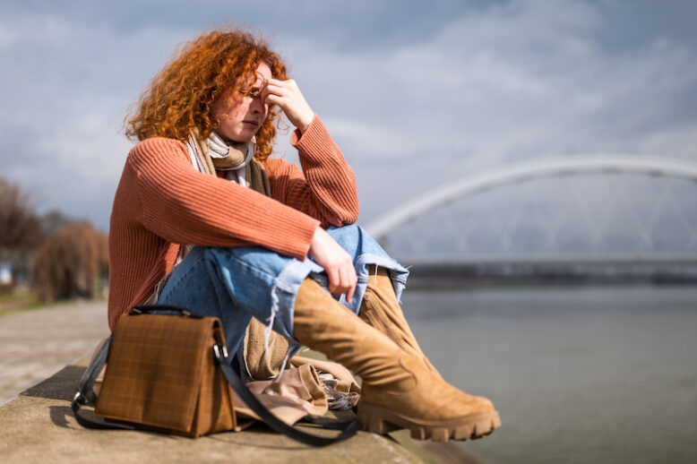 sad lady by a bridge