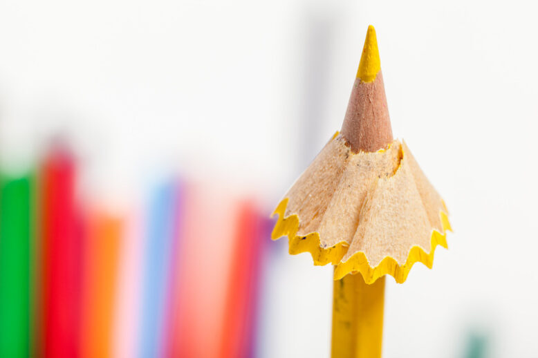 yellow pencil surrounded by pencil shavings