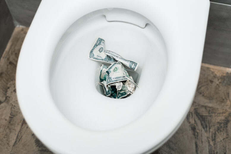 top view of dollar banknotes in toilet bowl in modern restroom