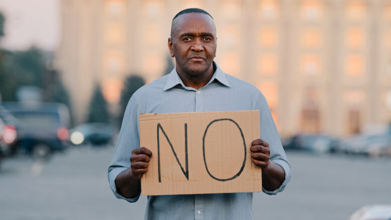 man protests against discrimination showing protest sign on strike