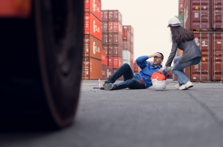 First aid for a container warehouse worker fainted while working in the bright sunlight and hot weather of a container storage yard