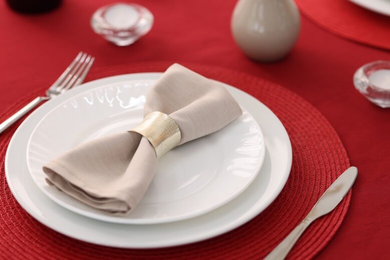 Clean plates, napkin and cutlery on table