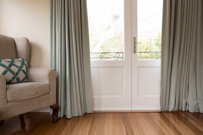 Closed door with sofa on wooden floor in living room at home