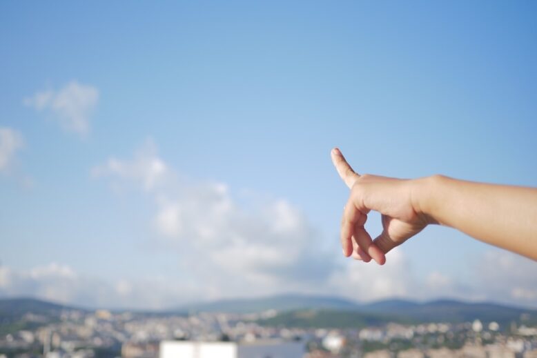 The image features a hand pointing over water